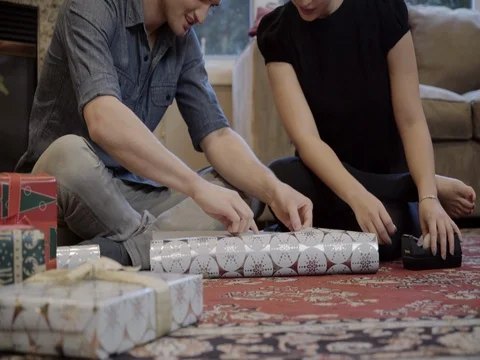 Medium shot of a couple wrapping a gift for Christmas 動画素材 73114954