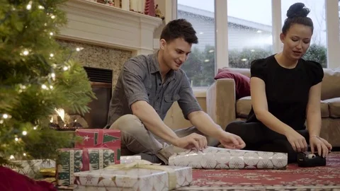Medium shot of a couple wrapping a gift for Christmas 動画素材 73115071