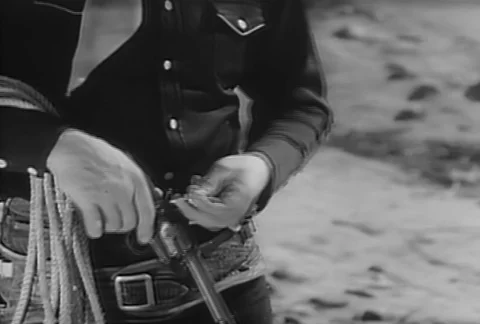 Medium shot of cowboy reloading his pistol, 1930s Stock Footage 95997389