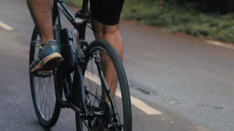 Medium shot of cyclist legs riding a bicycle on a road Stock Footage 165445360
