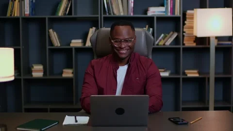 Medium shot of a dark-skinned man working online at a laptop at home, young man Stock Footage 263630373