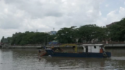 Medium shot, debris skimmer cleaning up trashes and garbage on Martapura river Stock Footage 156995946