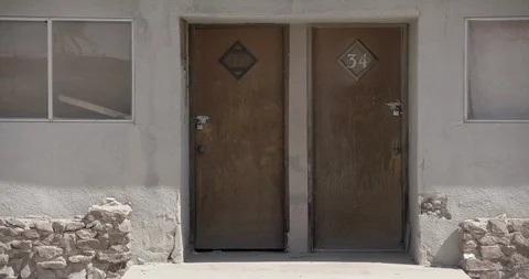 Medium Shot Detail on Two Doors to Abandoned Motel in Desert Stock Footage 89942900