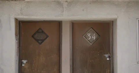 Medium Shot Detail on Two Doors to Abandoned Motel in Desert - Tilt Down Stock Footage 89942904