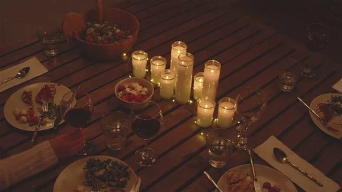 Medium shot of a dinner table while a woman swirls her wine glass Stock Footage 83019224