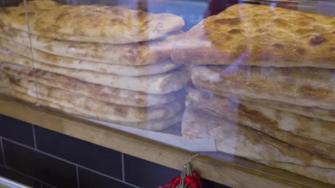 Medium shot of a display counter showcasing whole focaccias Stock Footage 303816179
