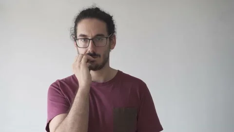 Medium shot of distracted young man biting his nails looking at camera Stock Footage 161551818