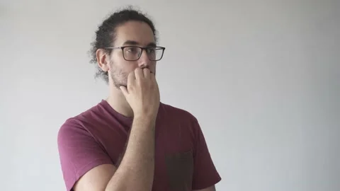 Medium shot of distracted young man biting his nails looking away Stock Footage 161551834