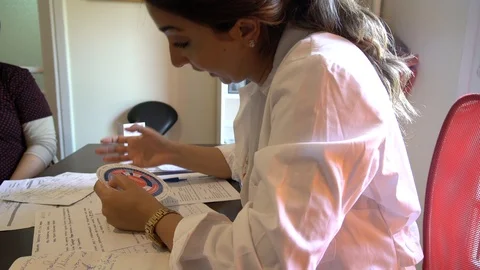 Medium shot of doctor's hands going through exams Stock Footage 113348064