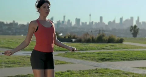 Medium shot of Eurasian female exercise skipping in the park Stock Footage 138253692