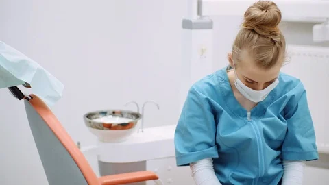 Medium shot of exhausted dentist sitting at chair Stock Footage 125572191