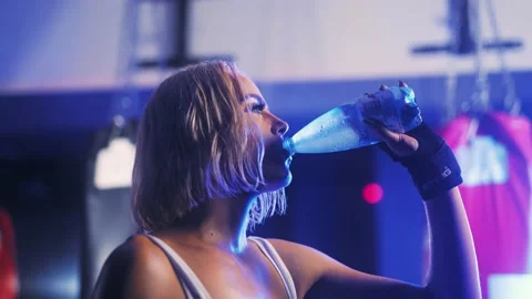 Medium shot of female athlete drinking bottle of water, slow motion 4K Video stock 202169360