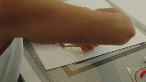 Medium shot of female collage artist's hands sticking paper in her workshop Stock Footage 336474470