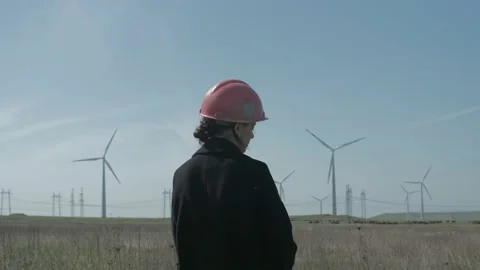 Medium shot of female engineer standing in the middle of the windmill Stock Footage 238009216