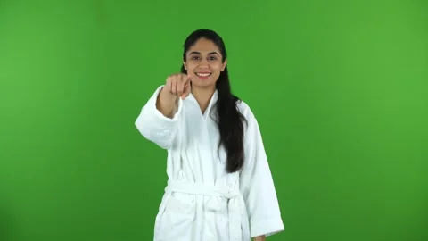 Medium shot of a female model in bathrobe pointing something on the green scr... Stock Footage 275809579