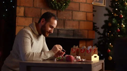 Medium shot of focused young man writing number on red bag by brush and white Stock Footage 164093808