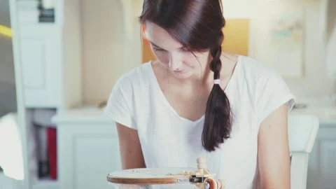 Medium shot: The girl embroiders using decorative stones and hoops Vidéo 69844624