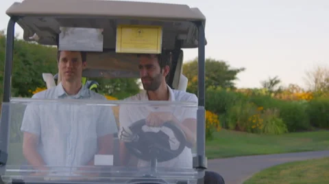 Medium shot of golfers riding golf cart Stock Footage 60110244