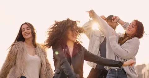 Medium shot of group of friends dancing together to music at sunset Stock Footage 85126492