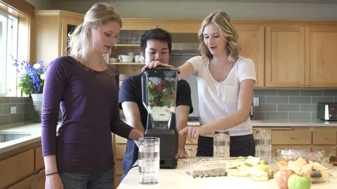 Medium shot of group of friends turning on the blender in a kitchen 動画素材 76537853