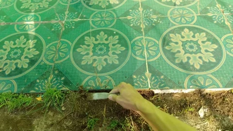 Medium shot of Hand holding metal tool scraping weeds Stock Footage 333015847