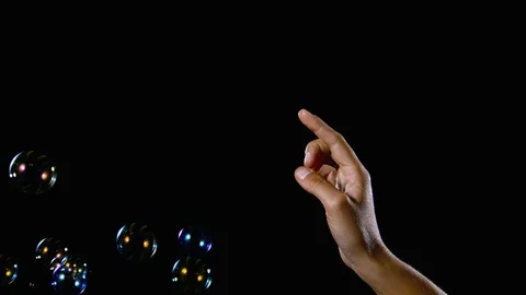 Medium shot hand popping bubble slow motion on black background Stock Footage 91470837