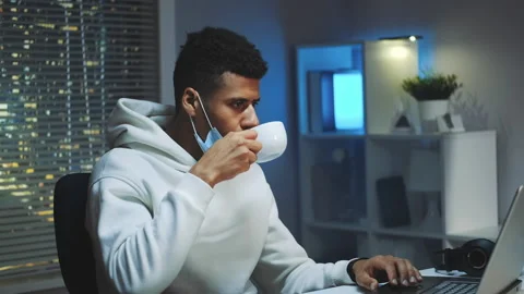 Medium shot of Handsome multiracial man drinking a cup of coffee and working on Stock Footage 153093491