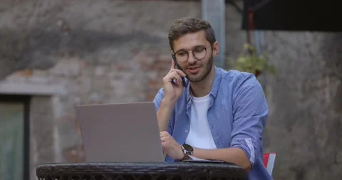 Medium shot of handsome young man wearing blue shirt working on laptop computer Stock Footage 164674099