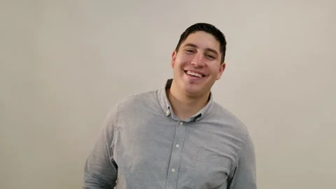 Medium shot of Hispanic dark-haired man smiling widely and laughing at camera Stock Footage 250315820