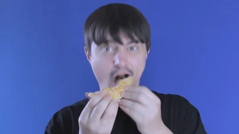 Medium shot hungry guy eats a burger greedily. Unhealthy food Stock Footage 137970827