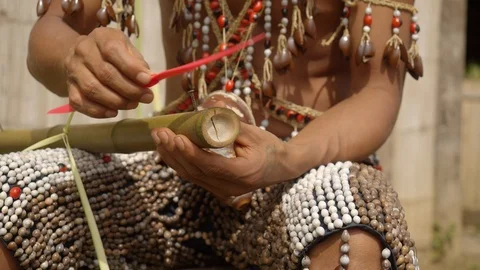 Medium shot of indigenous man trying to build a flying device by attaching a Stock Footage 113179969