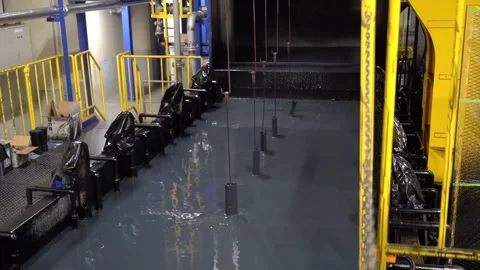 Medium shot of industrial electro-coating process dipping metal parts into a Stock Footage 334275012