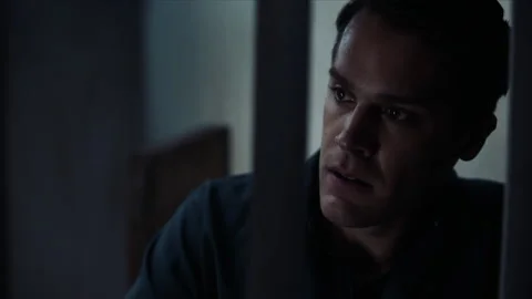 Medium shot of inmate looking out from behind bars, 2000s, USA - Reenactment 스톡 동영상 243736647