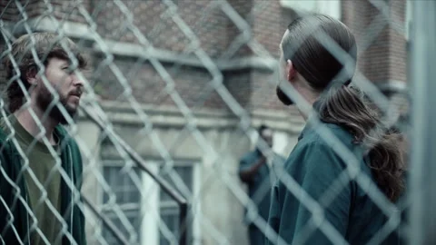 Medium shot of inmates talking at prison yard, 2000s, USA - Reenactment 스톡 동영상 243734794