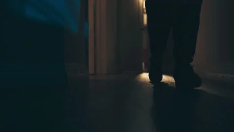 Medium shot of an intruder walking down a dark hallway, USA - Reenactment Stock Footage 237695998