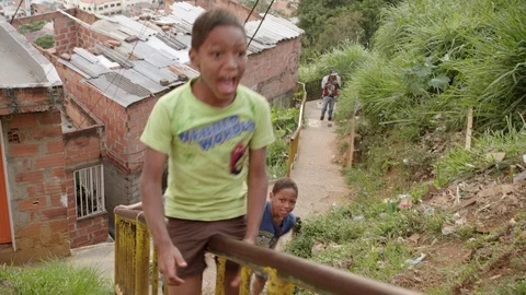 Medium shot of kids in the streets of Comuna 13, a slum in Medellin, Colombia Stock Footage 105029828