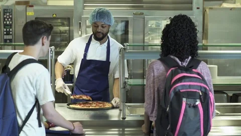 Medium shot kitchen staff serving food for high schoolers 動画素材 76230668