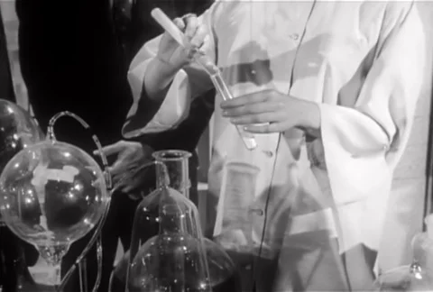 Medium shot of lab technician pouring powder into vial, 1950s Stock Footage 95348325
