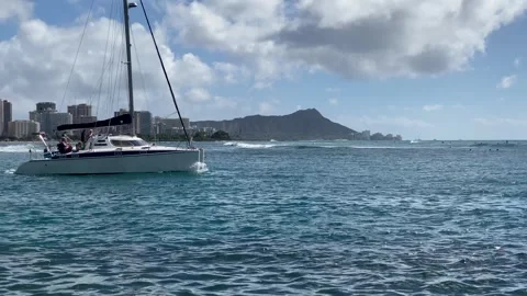Medium-shot - Large catamaran sails past with diamond head background Stock Footage 291464206