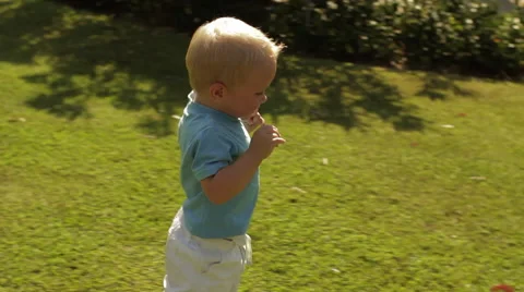 Medium shot of little boy running across field. Stock Footage 43630157