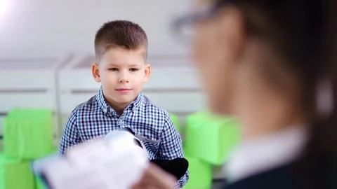 Medium shot little cute boy discussing problem with female child psychologist at Stock Footage 105928922
