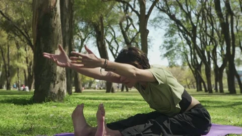 Medium shot of a lovely young woman doing yoga and stretching at park Stock-Footage 140230853
