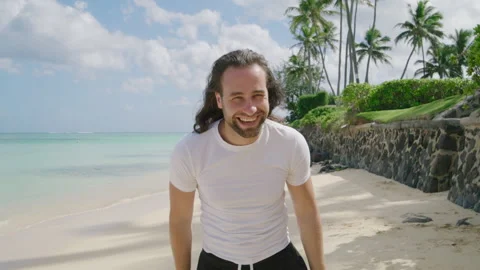 Medium shot of macho man with long hair standing on the beach of tropical island Stock Footage 266871546