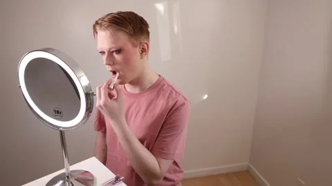 A Medium Shot of a Man Applying Lip Gloss in Front of Mirror Stock Footage 310141011