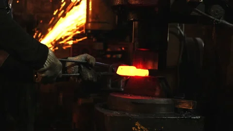 Medium shot of a man with an automatic anvil and red-hot metal Stock Footage 143462818