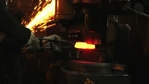 Medium shot of a man with an automatic anvil and red-hot metal Stock Footage 201455828