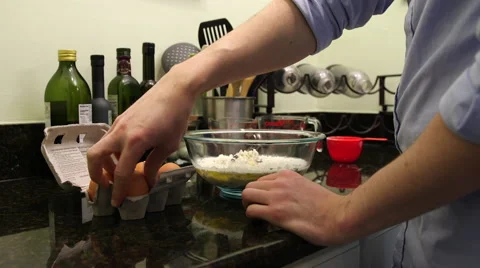 Medium shot of man breaking egg into mixing bowl Stock Footage 61401401