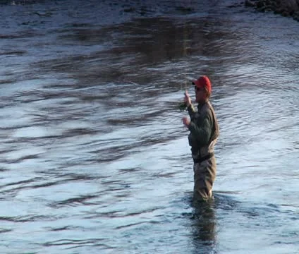 Medium shot  of man flyfishing in River in wintertime Stock Footage 21615901