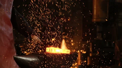 Medium shot of a man with a hammer hitting red-hot metal Stock Footage 143462215