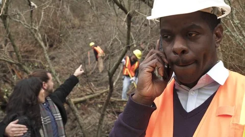Medium shot of a man in hard hat talking on his mobile phone 動画素材 73249781